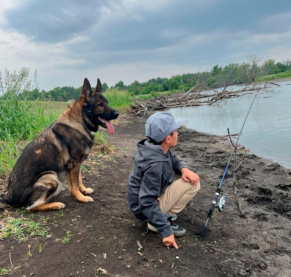boy and dog fishing family protection dog https://ultimatek9.com